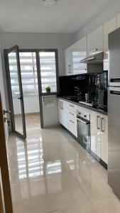 una grande cucina con armadietti e elettrodomestici bianchi di Apparemment a Minaret de Mansuria