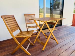 Ein Holztisch und zwei Stühle auf einem Holzboden in der Unterkunft Castlemaine Short Stays in Castlemaine