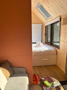 En eller flere senge i et værelse på Tiny houses PAMPA Lodges - étang & bain nordique