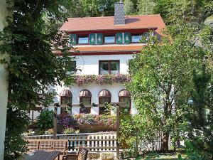 ein Haus mit einem Zaun und Stühlen davor in der Unterkunft Pension Fuhrmann's Elb- Café in Bad Schandau