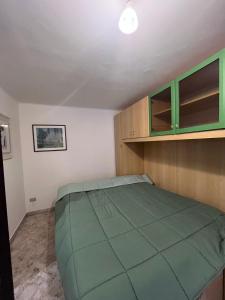 a bedroom with a green bed and wooden cabinets at Al Castello 2 in Bari