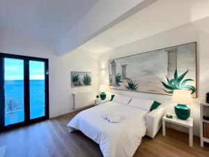 a bedroom with a white bed and a large window at Mimosa Seafront Apartment - Free parking Wi-Fi in Varazze