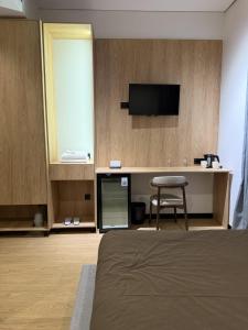 ein Hotelzimmer mit einem Bett und einem Schreibtisch mit einem Fernseher in der Unterkunft Mosh Mosh Boutique Hotel in Almaty