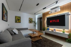 een woonkamer met een bank en een tv bij Modern 2BR Condo 10min from beach and Souk in Agadir +28 foto's