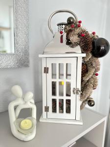 een wit poppenhuis met een kerstkrans op een tafel bij LIUxSAU apartmentai in Mažeikiai