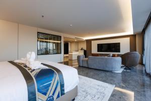 een hotelkamer met een bed en een bank bij Marquis Hotel in Ban Bang Toei (1)