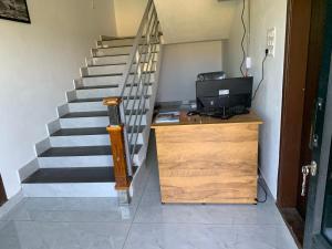 a staircase with a desk with a computer and a laptop at Elysian in Mananthavady