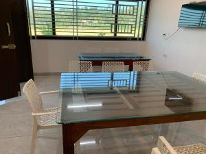 a glass table and chairs in a room at Elysian in Mananthavady +5 photos