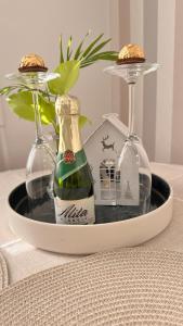 twee glazen en een fles wijn op tafel bij LIUxSAU apartmentai in Mažeikiai