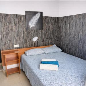 een slaapkamer met een bed met twee handdoeken erop bij San Jordi Tossa de Mar in Tossa de Mar