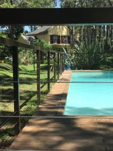 a fence around a swimming pool with a house in the background at Jardines del Bosque in Costa del Este