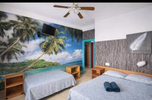 een slaapkamer met 2 bedden en een muurschildering van palmbomen bij San Jordi Tossa de Mar in Tossa de Mar