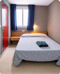 een slaapkamer met een bed met een blauwe handdoek erop bij San Jordi Tossa de Mar in Tossa de Mar