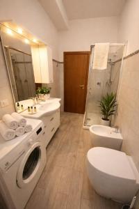 een badkamer met toilet, wastafel en wasmachine bij Lucens Domus Appartamento Roma quartiere Trieste - vicino Metro b1 - in Rome +23 foto's