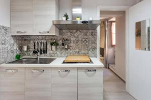 卡塔尼亚Two Rooms Bellini的带白色橱柜和水槽的厨房