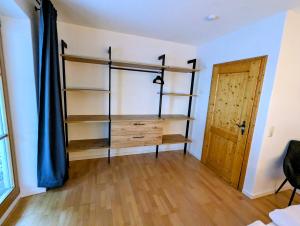 a room with a book shelf and a door at Geigerhof Bad Heilbrunn in Bad Heilbrunn