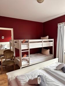 a bedroom with two bunk beds and a red wall at Unser Märchenhaus in Braunlage
