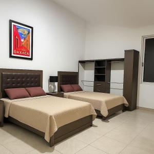 En eller flere senge i et værelse på Rento funcionales recamaras dentro de una casa residencial