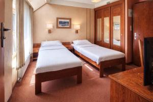 een ziekenhuiskamer met 2 bedden en een televisie bij Dom Oliwski in Gdańsk