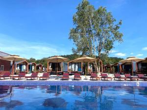 a pool at a resort with chairs and umbrellas at Royal C Resort in Koh Rong Island
