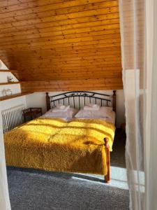 een bed in een kamer met een houten plafond bij Pension Libra in Velešín