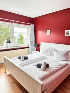 two beds in a bedroom with a red wall at Unser Märchenhaus in Braunlage