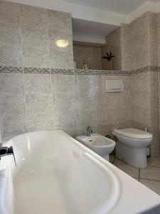 a bathroom with a bath tub and a toilet at Maison Berthod in Aosta