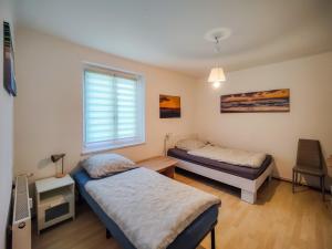 een slaapkamer met twee bedden en een raam bij FEWO Jänschwalde II in Jänschwalde Ost