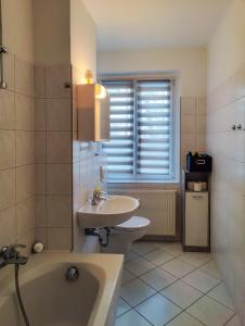 een badkamer met een wastafel, een bad en een toilet bij FEWO Jänschwalde II in Jänschwalde Ost +42 foto's