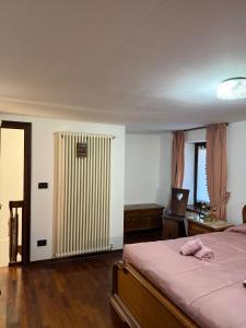 ein Schlafzimmer mit einem Bett und einem Heizkörper in der Unterkunft Maison Berthod in Aosta