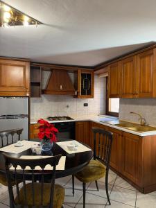 eine Küche mit Holzschränken und einem Tisch und Stühlen in der Unterkunft Maison Berthod in Aosta