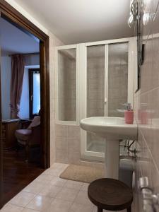 ein Badezimmer mit weißem Waschbecken und Fenster in der Unterkunft Maison Berthod in Aosta + 1 Foto