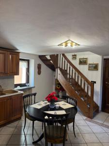 eine Küche mit einem Tisch mit Stühlen und einer Treppe in der Unterkunft Maison Berthod in Aosta