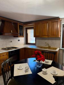 eine Küche mit einem Tisch mit einer Vase mit Blumen darauf in der Unterkunft Maison Berthod in Aosta