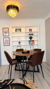 una sala da pranzo con tavolo, sedie e lampadario di Modern 1 bed super fast WiFi a Brentford Altre 13 foto
