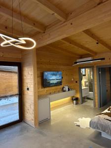 a bedroom with wooden walls and a flat screen tv at Suncatcher Djurdjevic Apartmani in Banja Luka