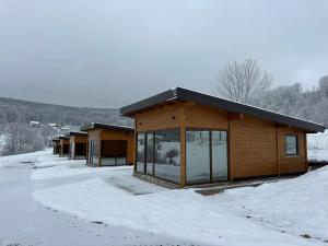 a log cabin with snow on the ground at Suncatcher Djurdjevic Apartmani in Banja Luka