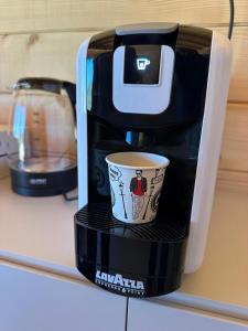 a coffee maker with a cup on a shelf at Suncatcher Djurdjevic Apartmani in Banja Luka +2 photos