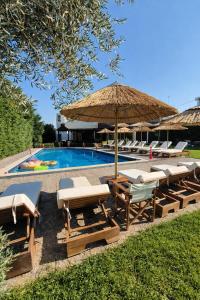 een zwembad met een stel stoelen en een parasol bij Maritina Apartments in Ixia