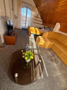 een woonkamer met een bank en een tafel met bloemen bij Pension Libra in Velešín