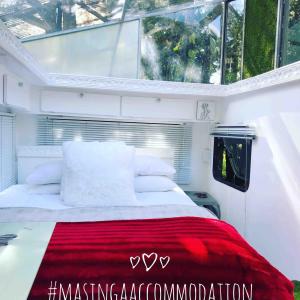 a bedroom with a large bed with a red blanket at Masinga in Hillcrest