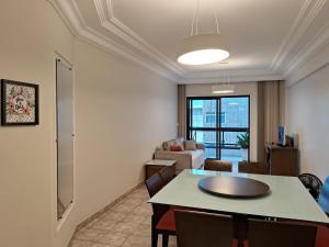 a living room with a table and a couch at Apartamento na Praia do Morro -160 metros da praia -Ar condicionado e internet -Perto de tudo in Guarapari