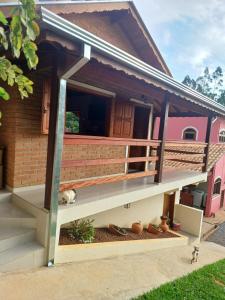 un gatto sdraiato sul portico di una casa di Chalés Maktub a Camanducaia