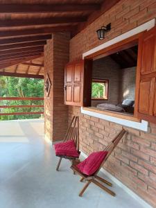 una camera con due sedie e un letto di Chalés Maktub a Camanducaia 1 altra foto