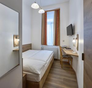 une chambre d'hôtel avec un lit et un bureau dans l'établissement Hotel Terminus, à Vienne