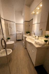 een badkamer met 2 wastafels, een toilet en een bad bij Lucens Domus Appartamento Roma quartiere Trieste - vicino Metro b1 - in Rome