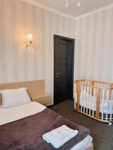 a bedroom with a bed and a baby crib at Hotel Winerooms Gudauri in Gudauri