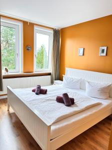 a bedroom with a large white bed with two brown slippers at Unser Märchenhaus in Braunlage