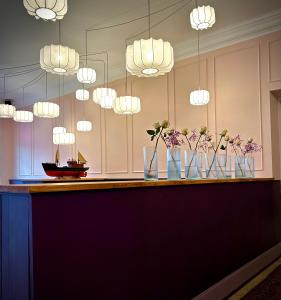 a bar with vases of flowers and lights at freustil Boutique Hotel in Binz