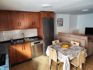 a small kitchen with a table with chairs and a sink at Bernal I, II y III in Los Sauces